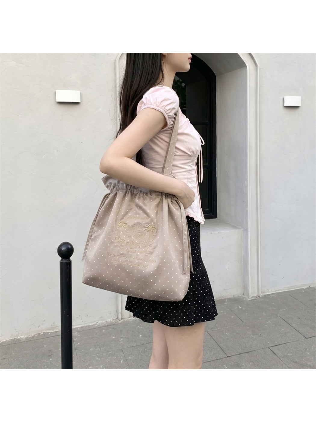 Cosbai polka dot shoulder bag placed on wooden surface with lighting