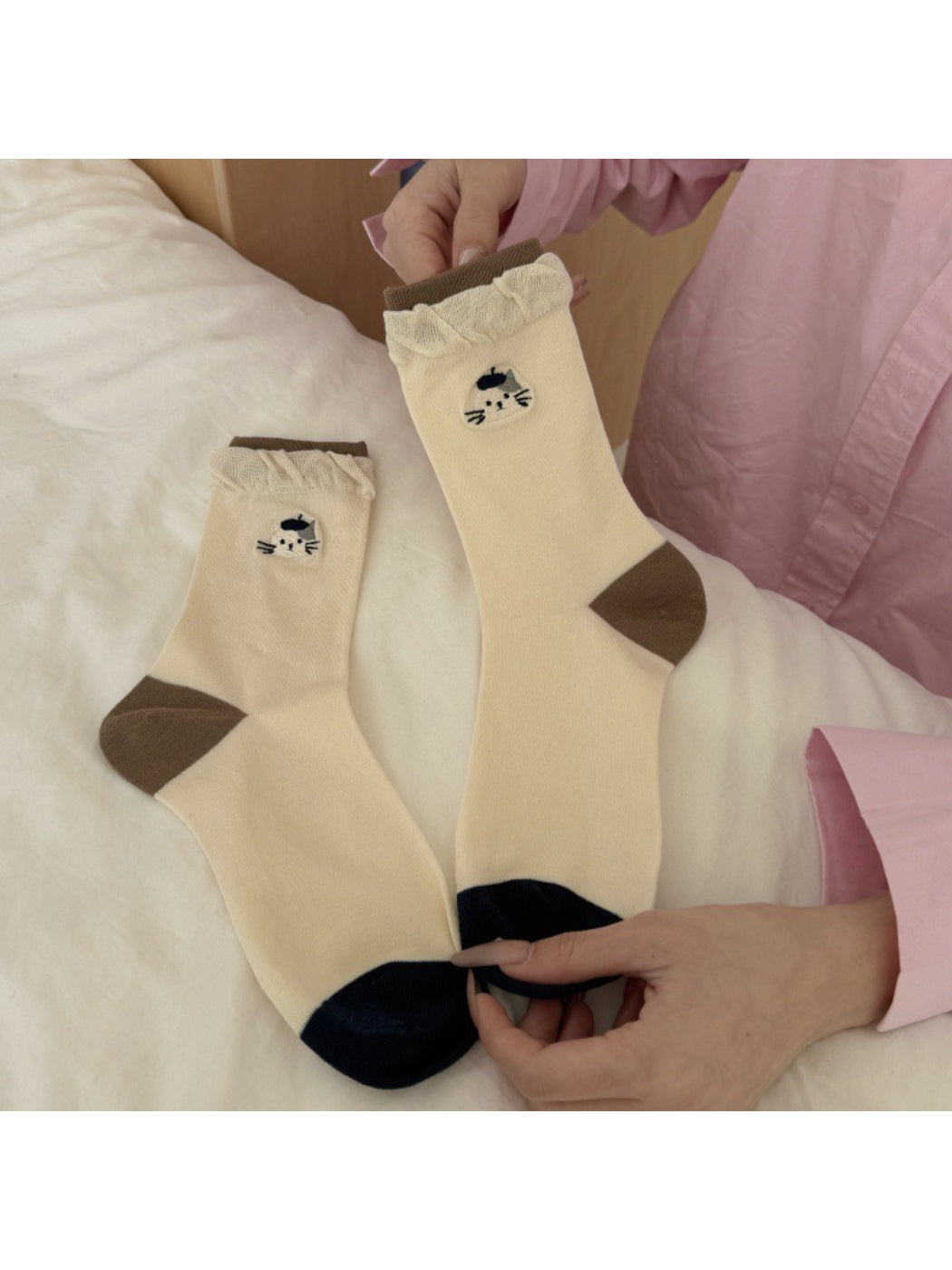 Folded white socks showing twisted cuff and black cat embroidery