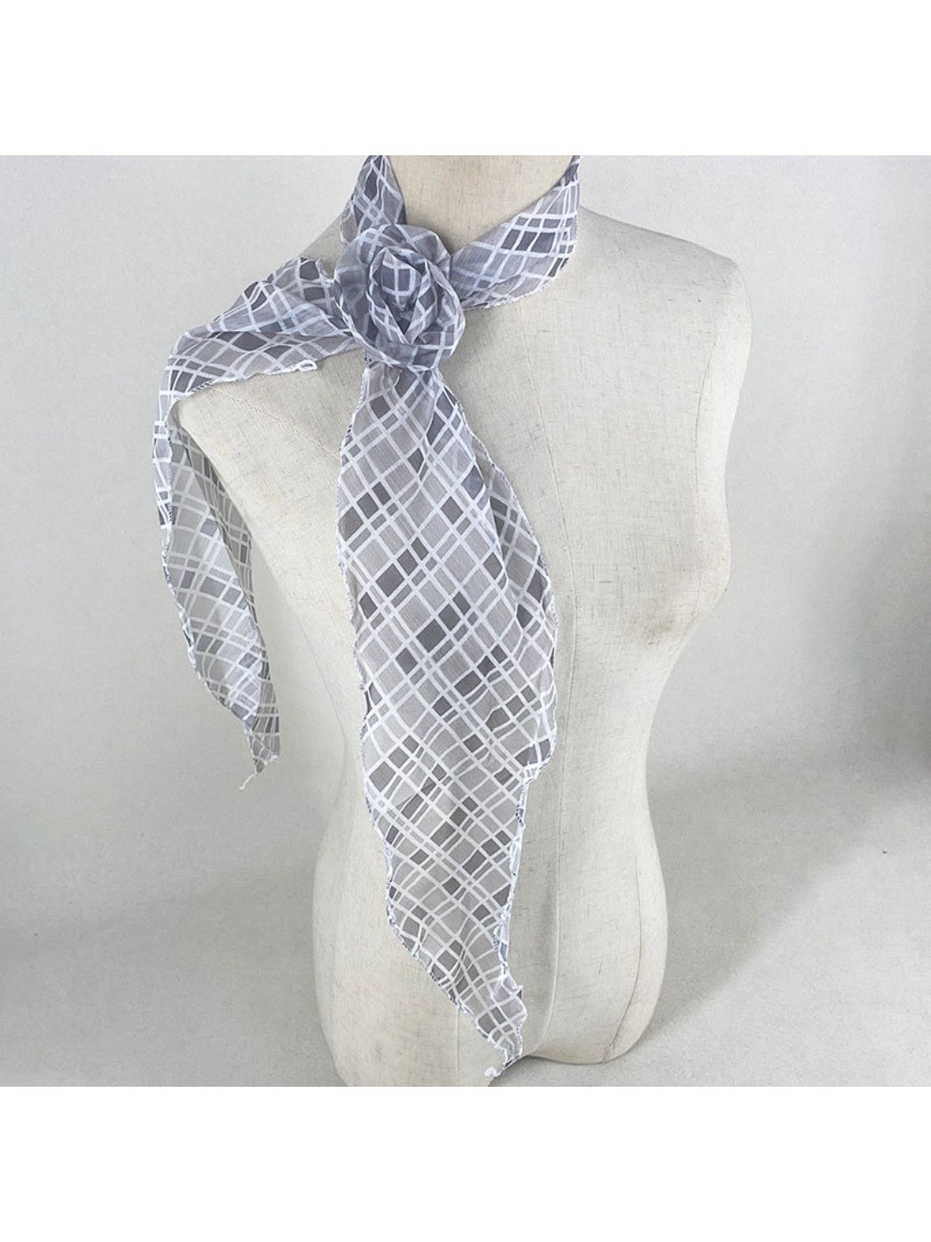 Scarf displayed on mannequin neck with vintage floral and polka dot design