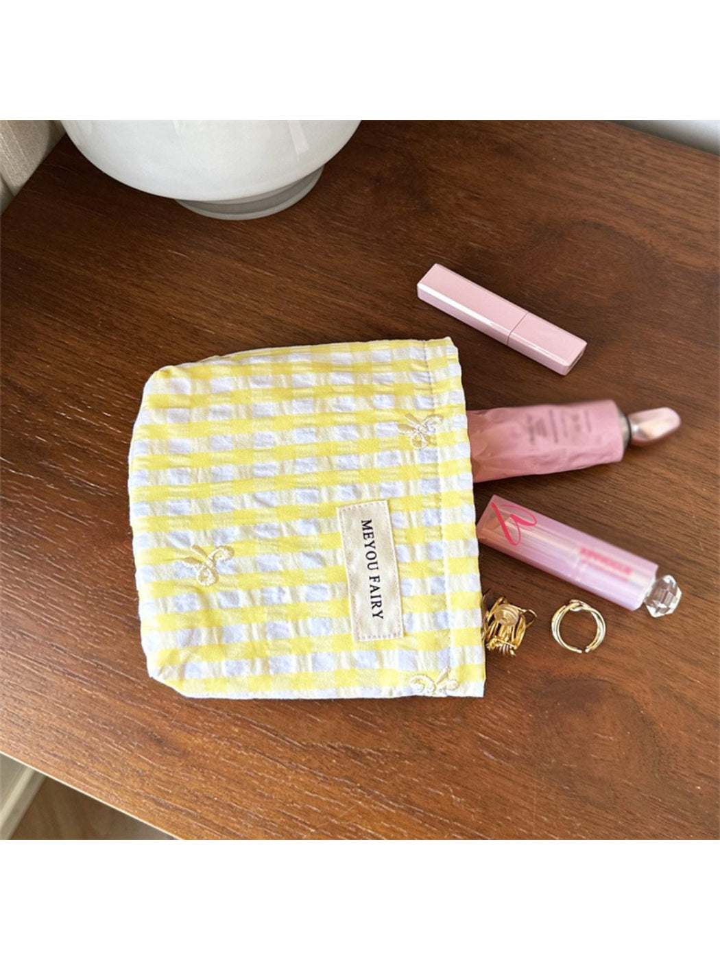 Cosbai pastel check zip pouch placed on white surface with soft lighting
