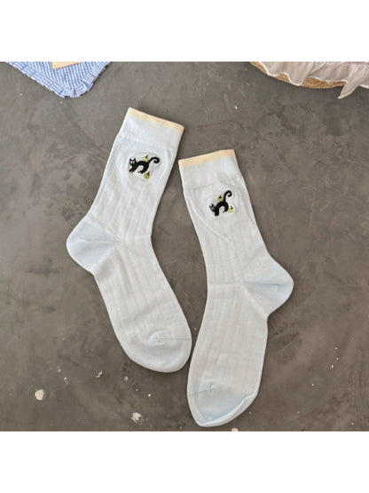 Rufia black cat crew socks worn with rolled-up pants showing full design