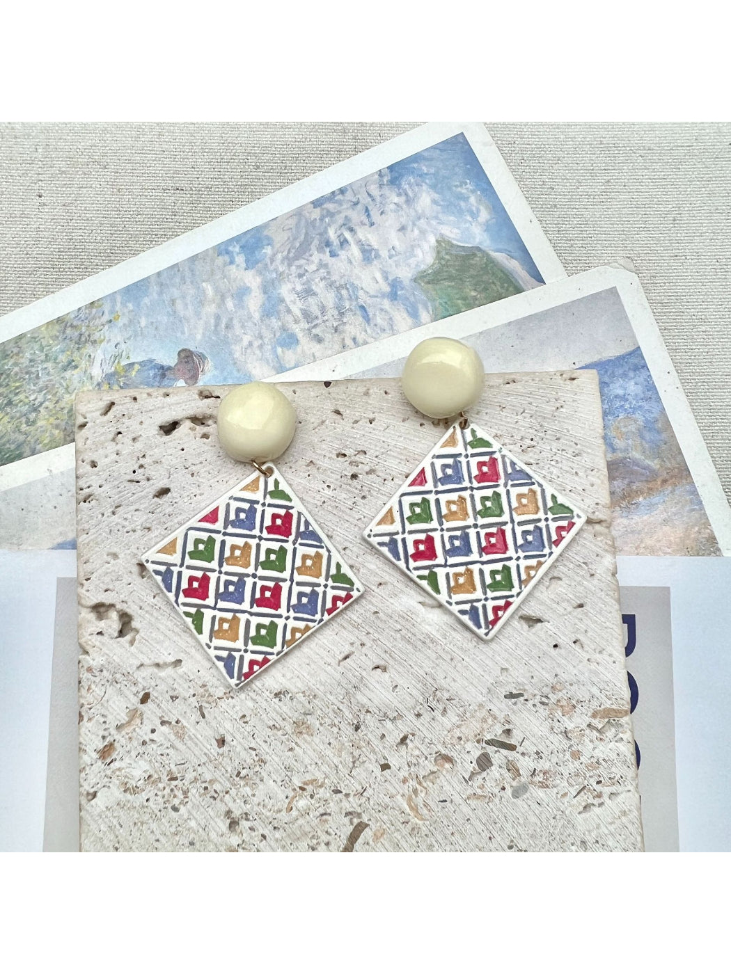 Earwish geometric diamond drop earrings displayed on a jewelry stand