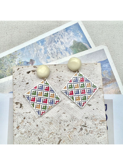 Earwish geometric diamond drop earrings displayed on a jewelry stand