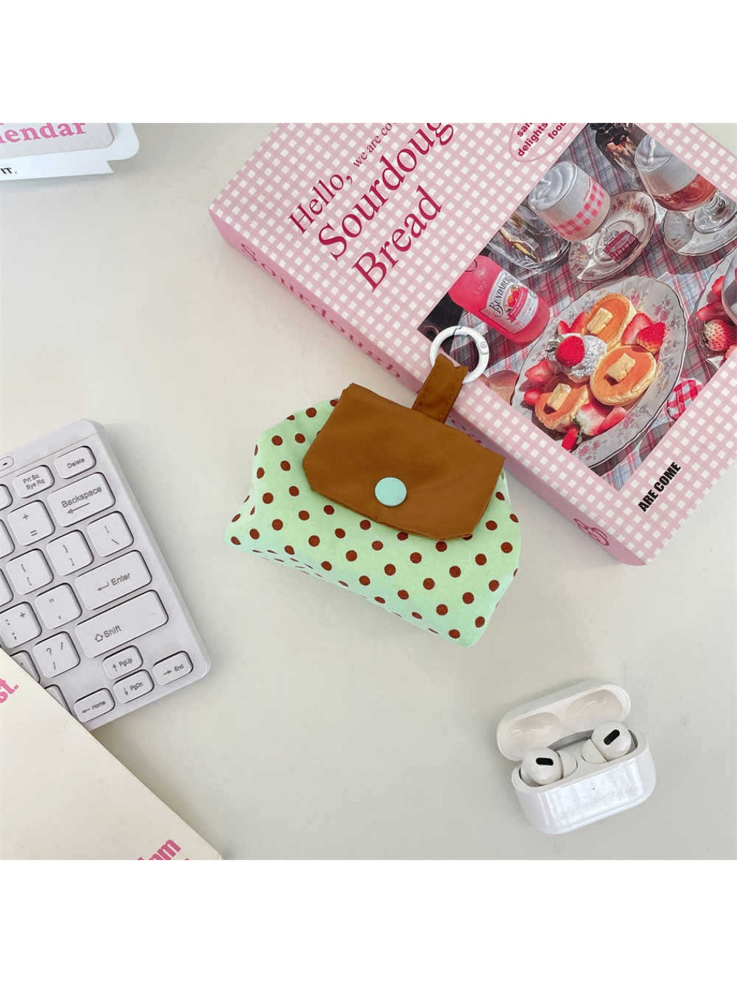 Cosbai mini polka dot pouch bag displayed with a hand holding it