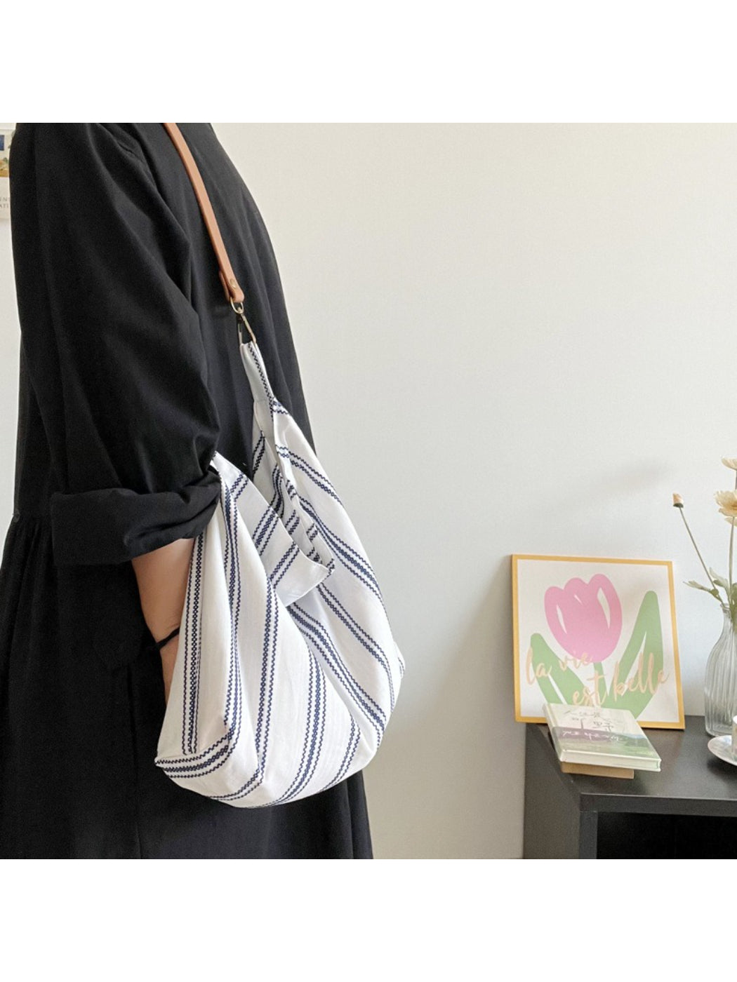 Cosbai blue stripe slouch shoulder bag displayed on a wooden surface with lighting
