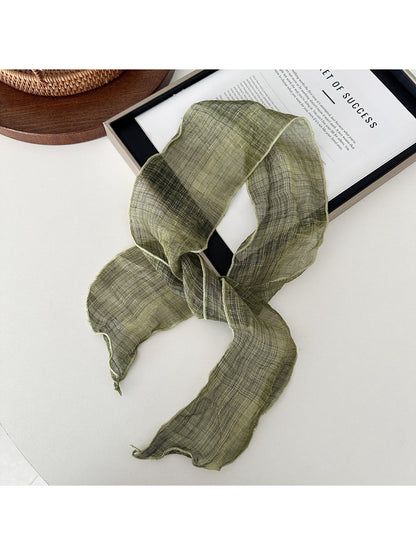 Soft textured skinny scarf folded neatly showing fabric texture and edges
