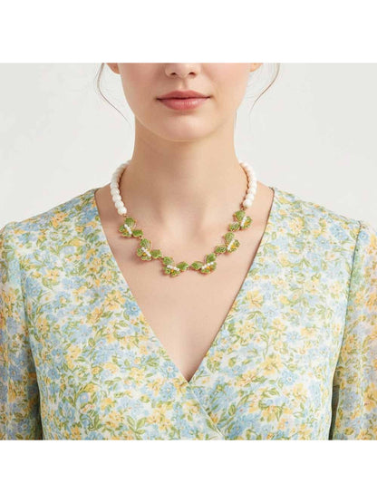 Close-up of Neckit Butterfly Necklace featuring beaded detail on a white background