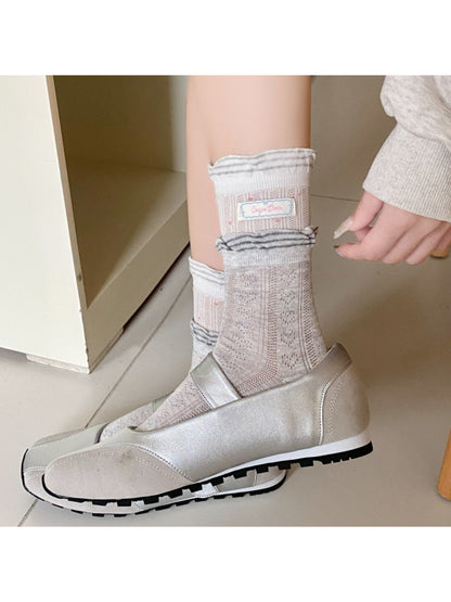 Rufia socks worn on feet highlighting the ribbon and check design