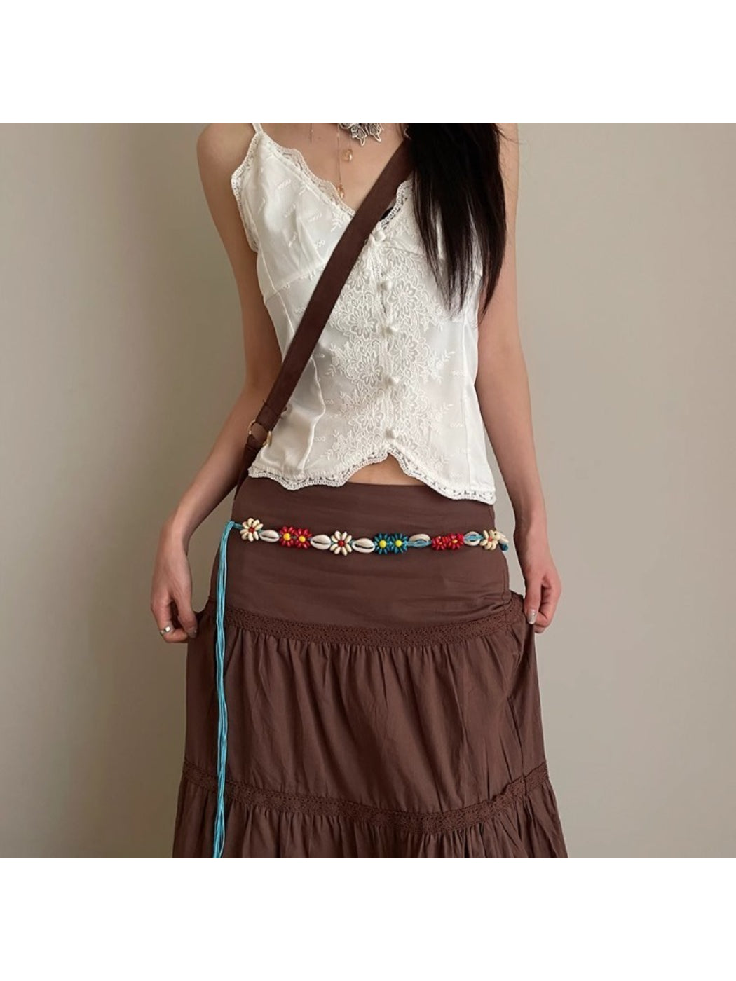 Beco floral shell shaped rope waist belt coiled on white background