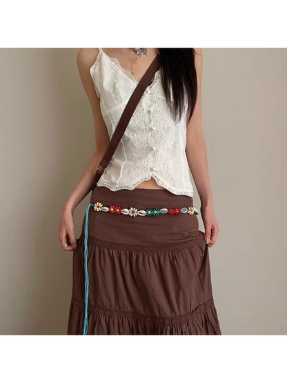 Beco floral shell shaped rope waist belt coiled on white background