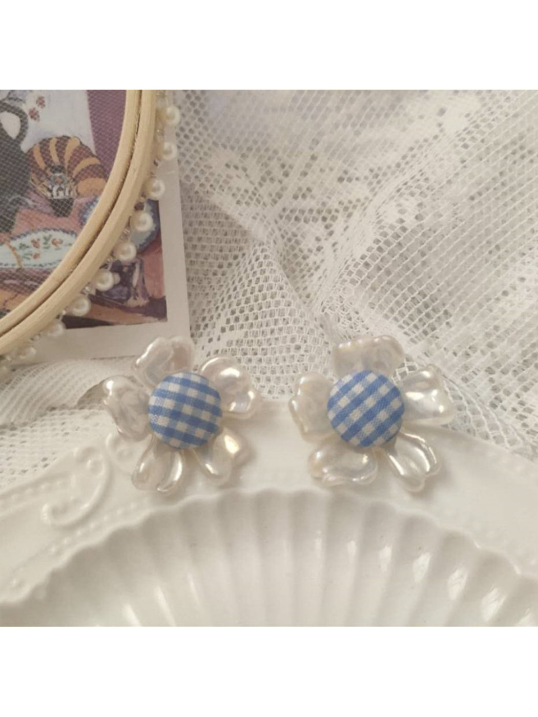 Close-up of Earwish gingham flower stud earrings with pink and white checkered pattern