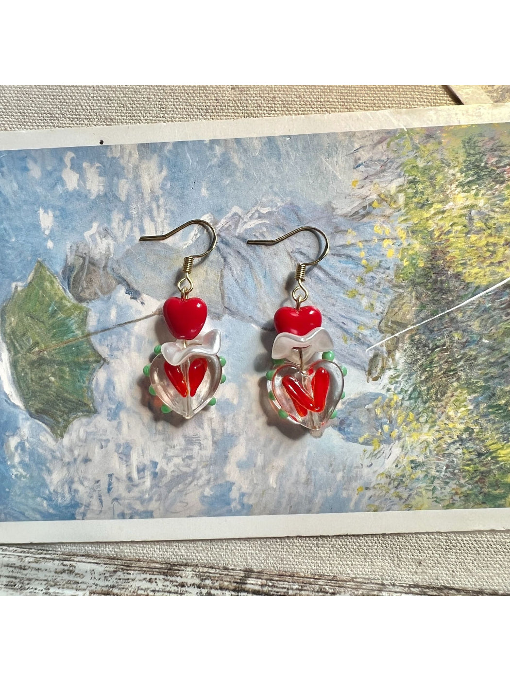 Side angle of Earwish Playful Apple Heart Earrings highlighting the gold-tone edges