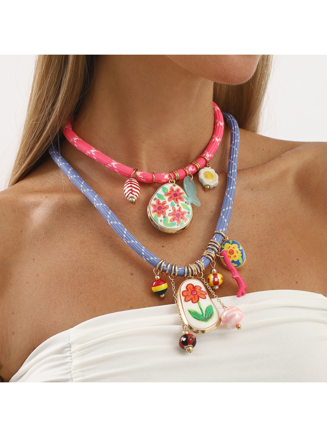 Colourful multi charm rope necklace with vibrant beads and silver accents on a white background