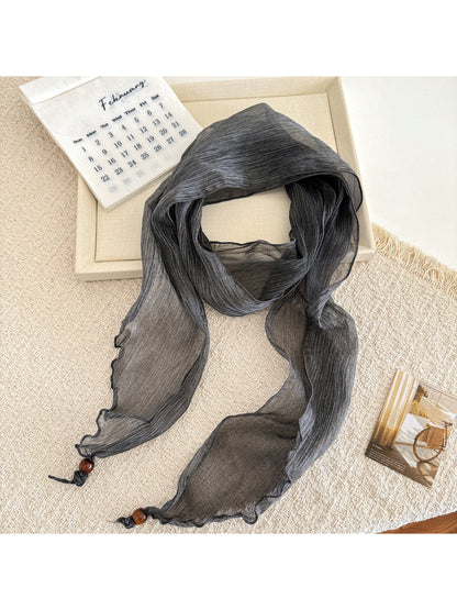 Model wearing soft pleated sheer skinny scarf styled around the neck