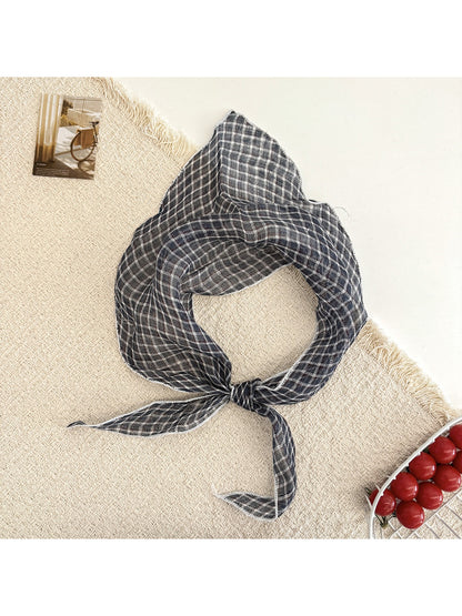 Model adjusting Scarvii triangle scarf around neck highlighting versatility and style