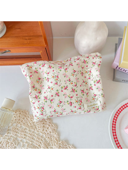 Cosbai cosmetic pouch with floral print placed on white surface with lighting
