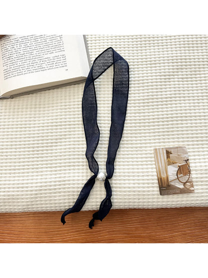 Sheer skinny scarf draped over shoulder highlighting bead design