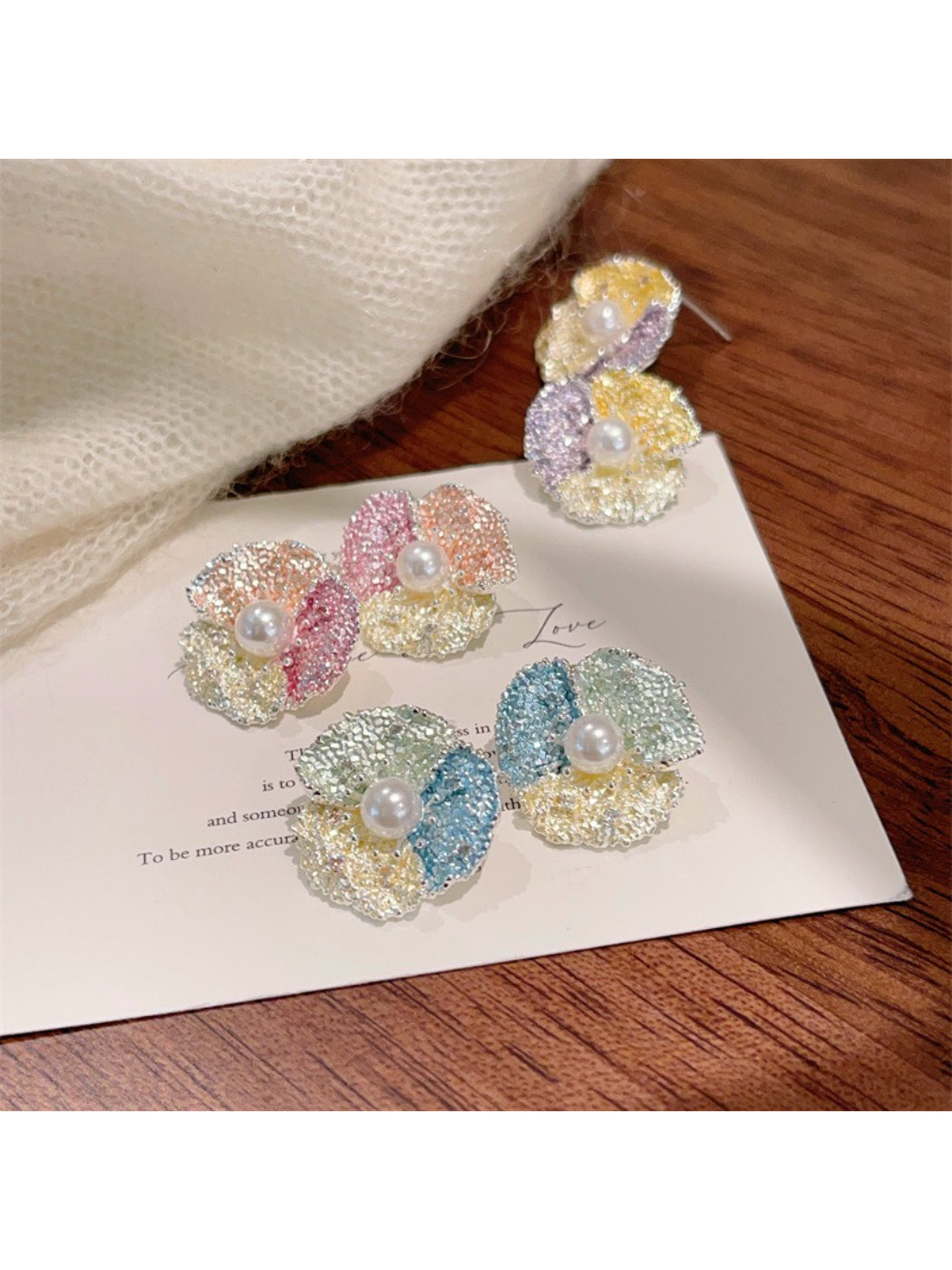 Close-up of Earwish soft color flower stud earrings on white background