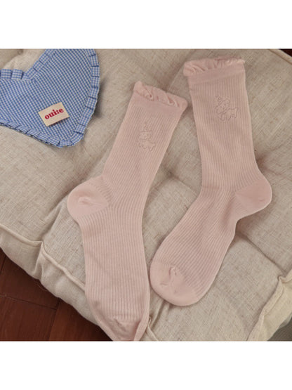 Multiple pairs of Rufia minimal animal crew socks in different colors arranged neatly