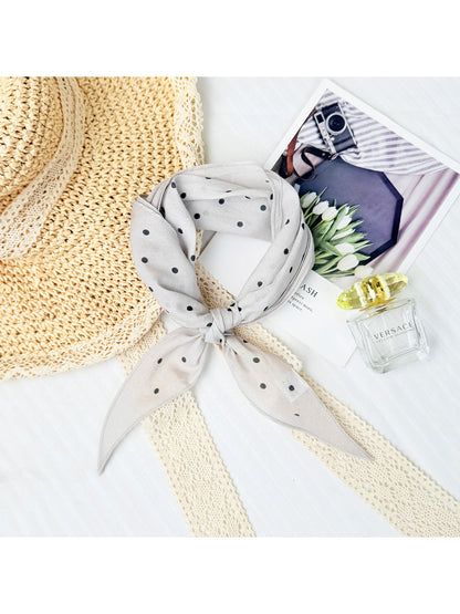Scarvii triangle scarf with dot print tied in a bow on a white mannequin
