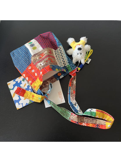 Side view of Cosbai Painterly Bloom shoulder bag showing strap and dog charm detail