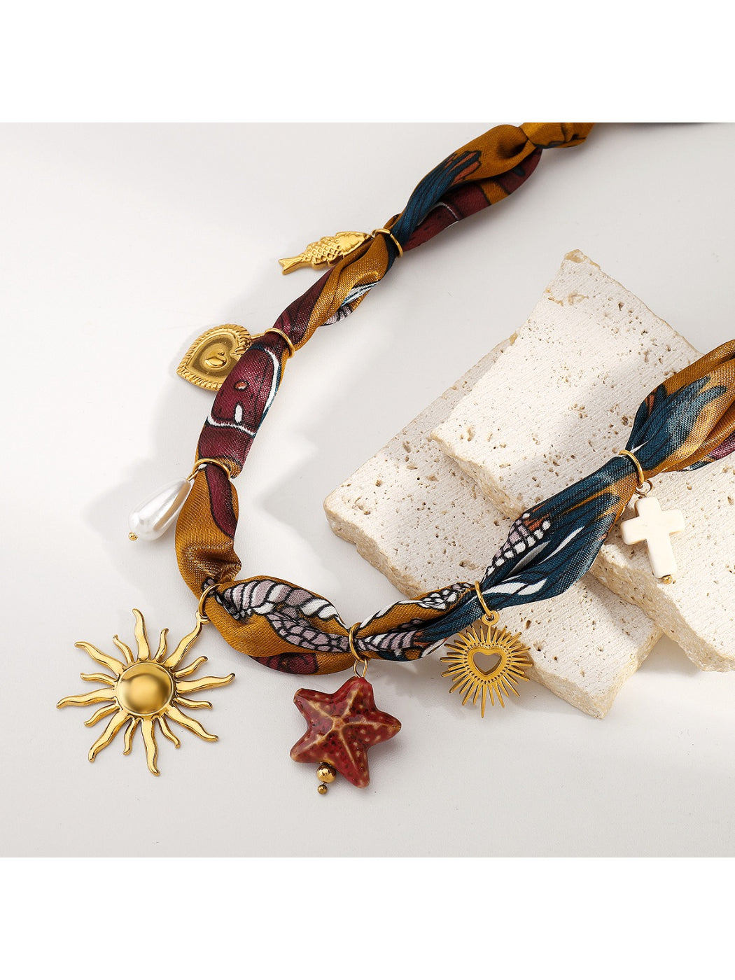 Boho charm fabric necklace displayed flat highlighting fabric texture and charms