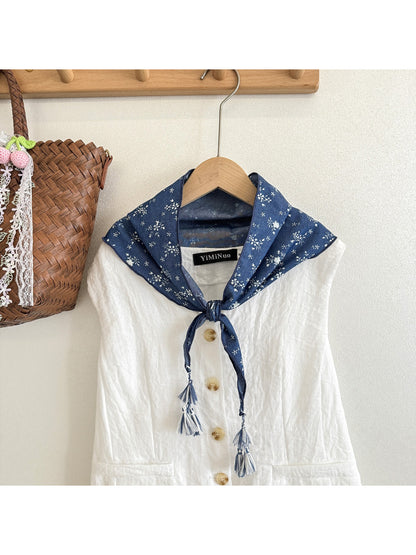 Model wearing blue floral tassel triangle scarf around the neck