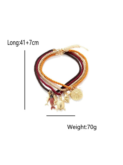 Neckit multi strand rope necklace with ocean charms arranged on a light surface
