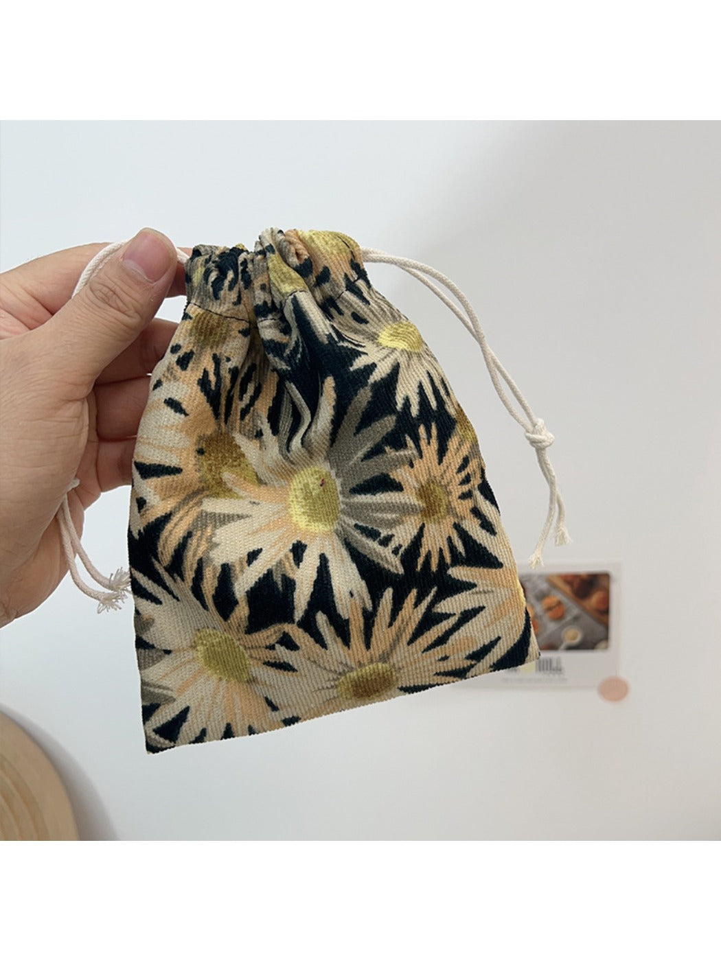 Cosbai floral drawstring pouch shown partially open with drawstrings visible