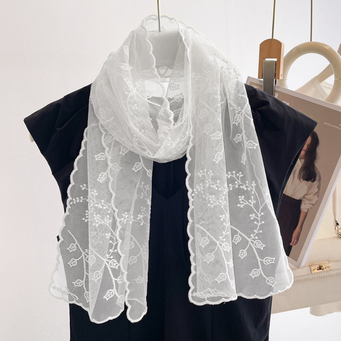 Close-up of embroidered floral patterns on sheer fabric scarf