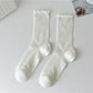Rufia beige crew socks displayed flat with visible ribbing and ruffle trim