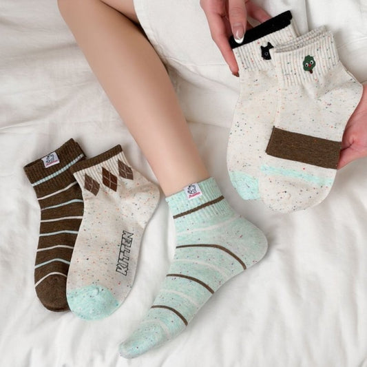 Pair of Rufia casual speckled knit crew socks in neutral tones displayed flat