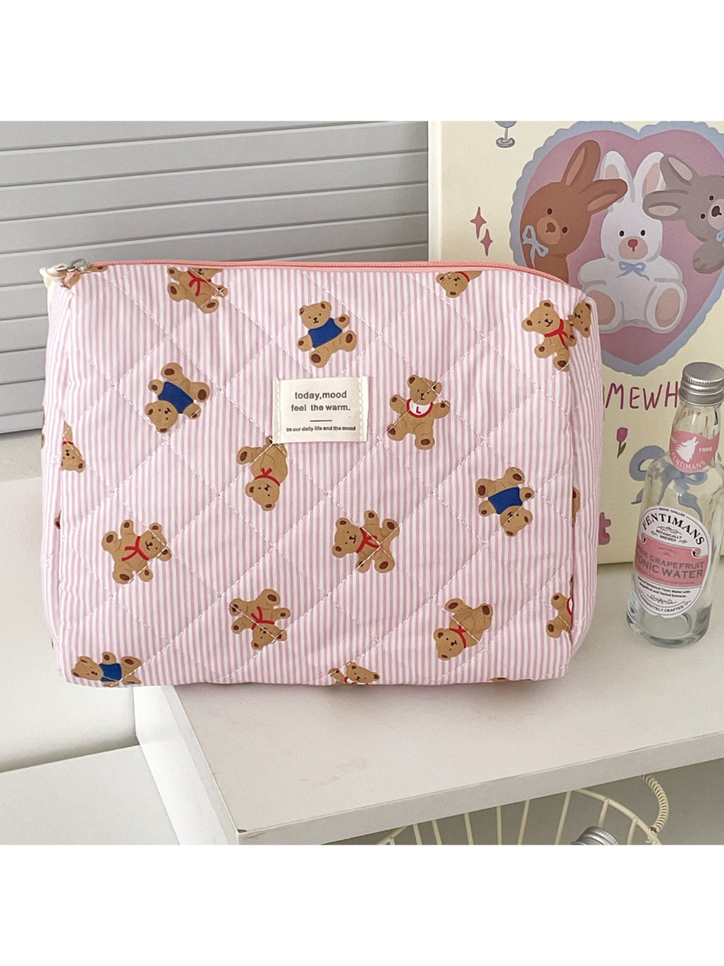 Close-up of teddy bear makeup bag showing soft plush texture and facial details