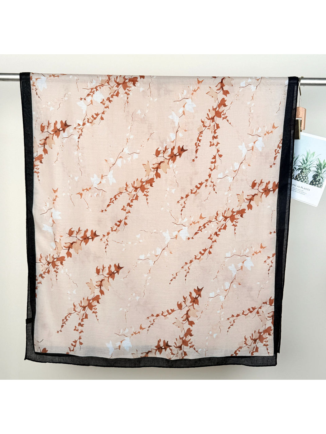 Folded Scarvii leaf print wrap scarf with visible green and beige leaves
