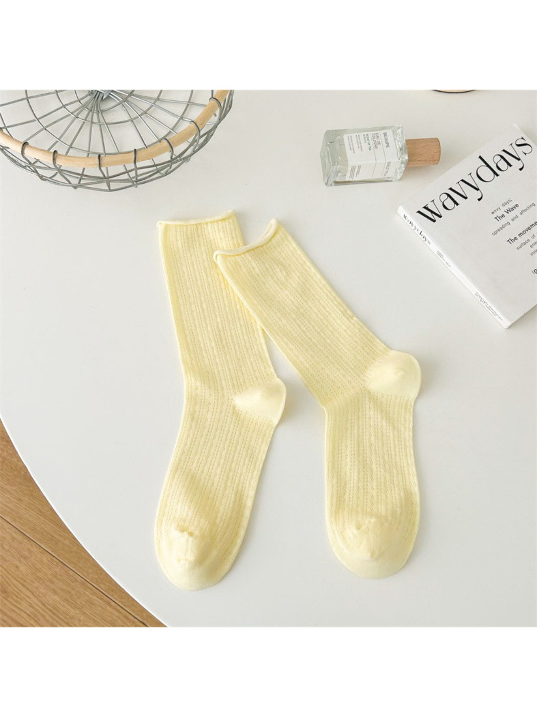 Beige Rufia crew socks displayed with a casual outfit on a mannequin
