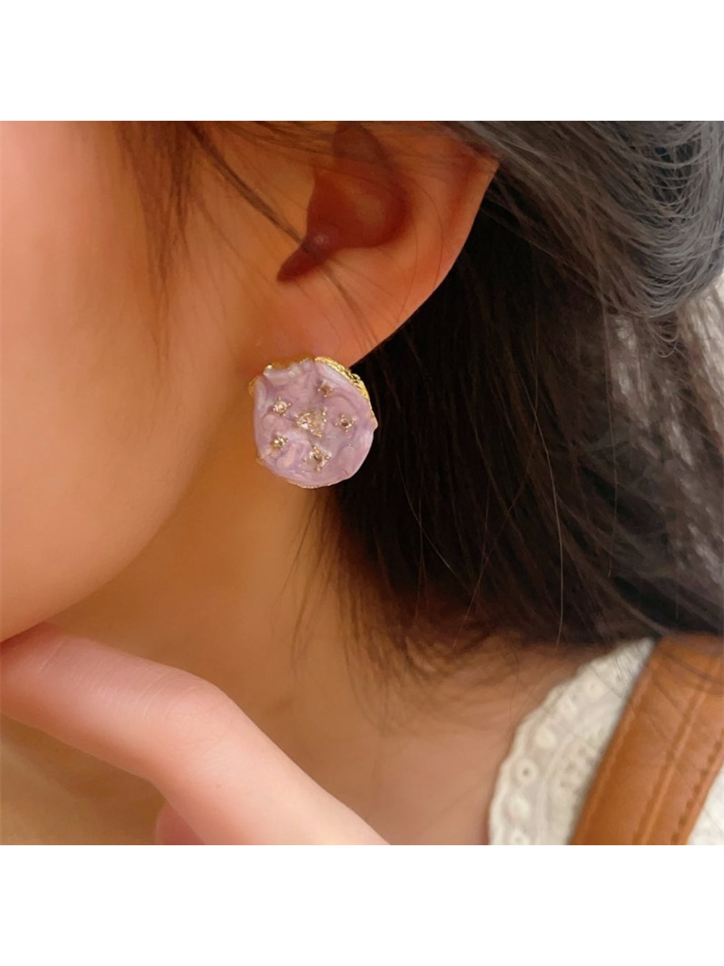Close-up of Earwish floral stud earrings showing pastel pink and green petals