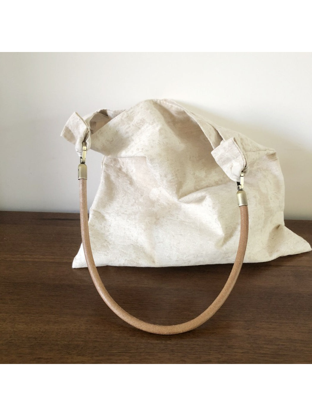Close-up of ivory hobo bag pattern and stitching details