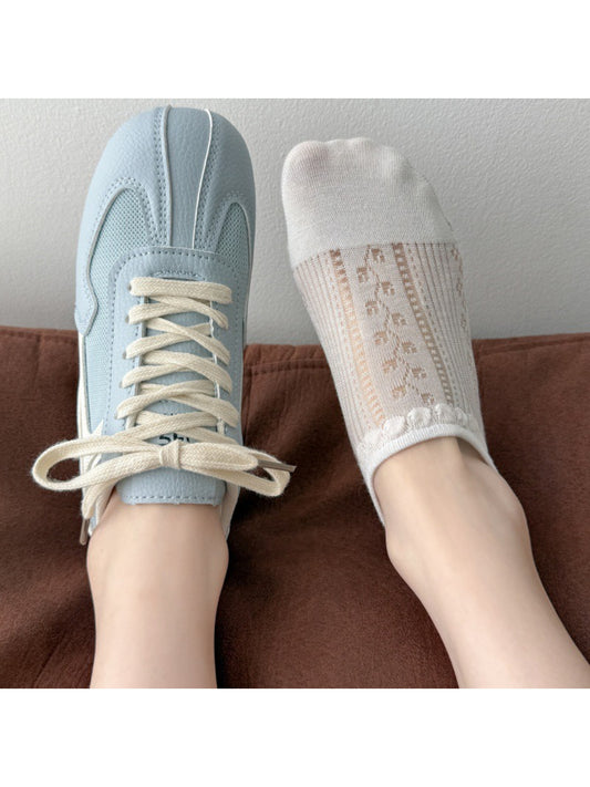 Pair of Rufia dainty open knit no show socks in light beige on white background