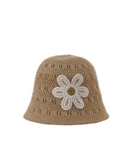 Model wearing Haila open weave flower hat outdoors with greenery background