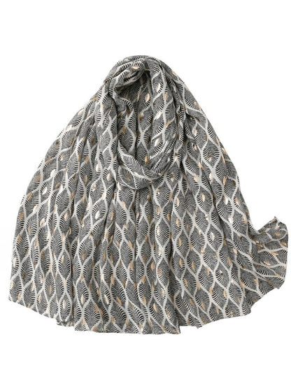 Close-up of feather pattern on soft fabric scarf showing detailed texture and pastel hues