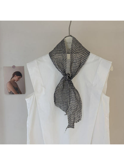 Model wearing Scarvii skinny scarf tied loosely with gingham and stripe print