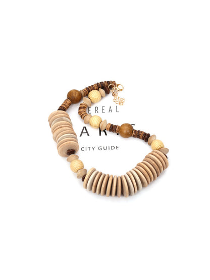 Neckit bead necklace displayed coiled to highlight its neutral earthy color palette