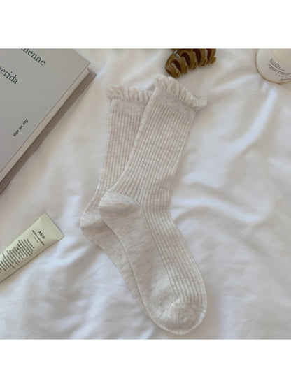 Side view of Rufia white crew socks showing lace trim