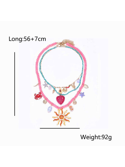 Neckit layered charm necklace with sun and heart detail styled with casual outfit