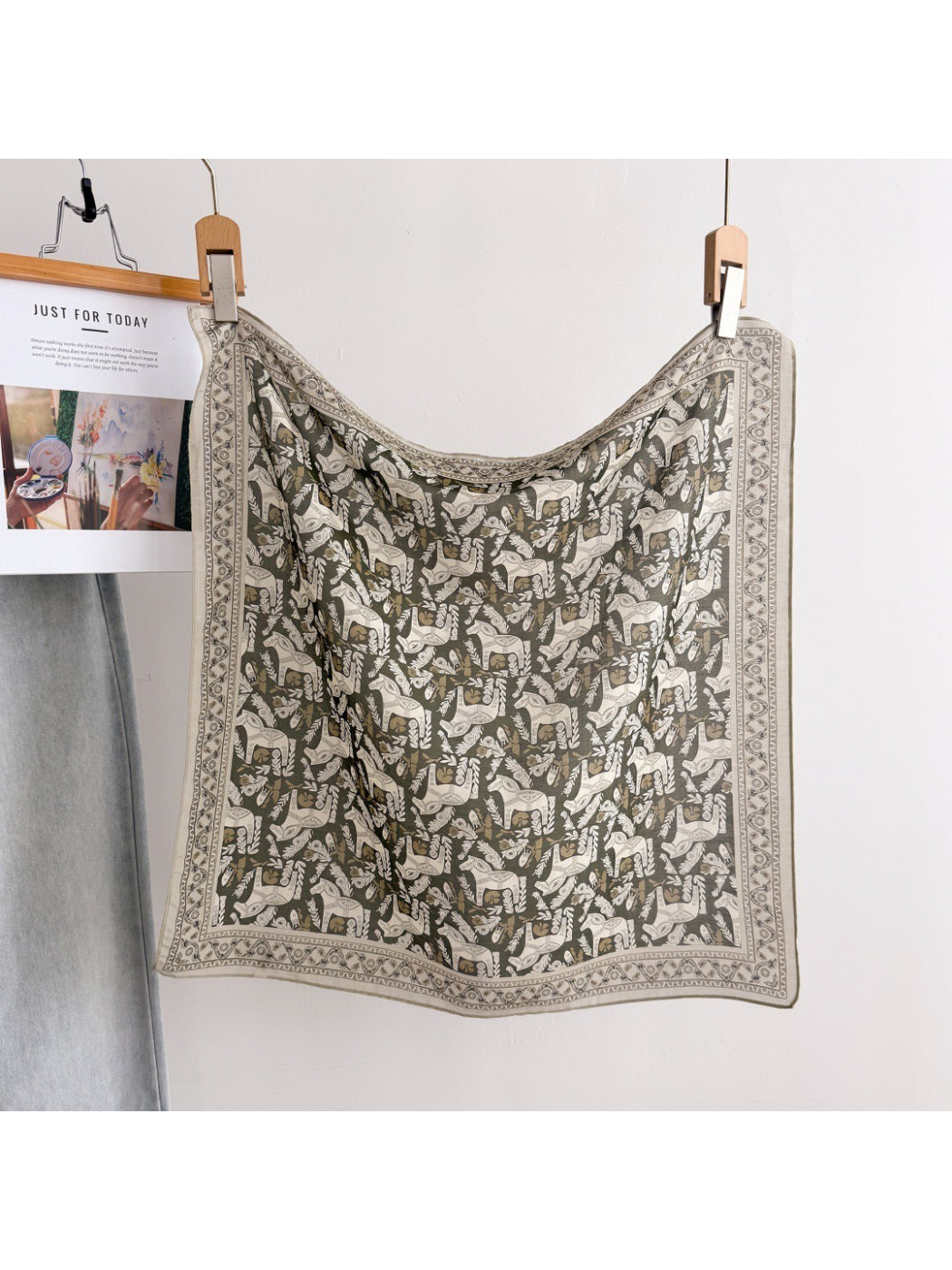 Close-up of Scarvii scarf fabric with detailed botanical illustrations in soft colors