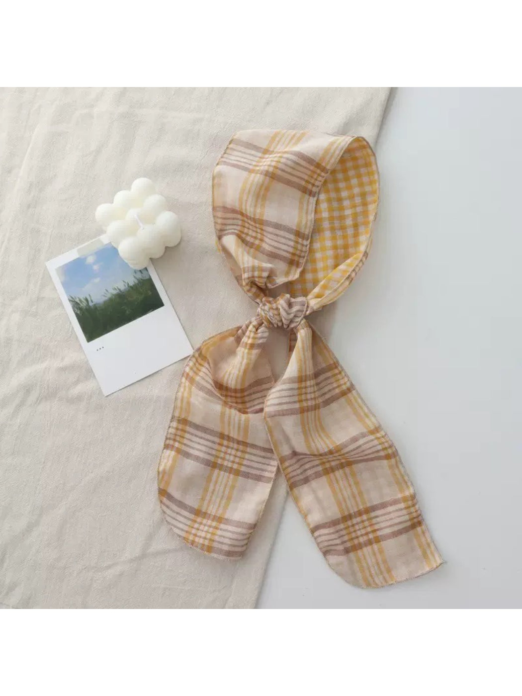 Scarvii Everyday Plaid Skinny Scarf folded neatly on a wooden surface