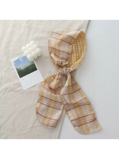 Scarvii Everyday Plaid Skinny Scarf folded neatly on a wooden surface