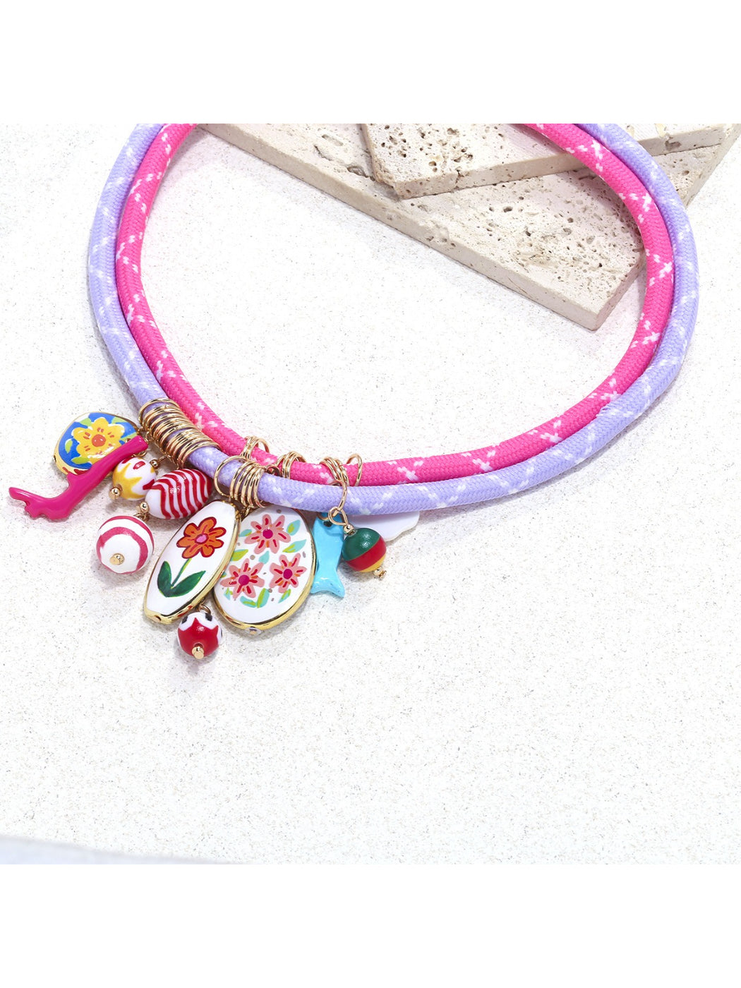 Side view of Neckit Charm Cluster Necklace with clustered charms on rope chain