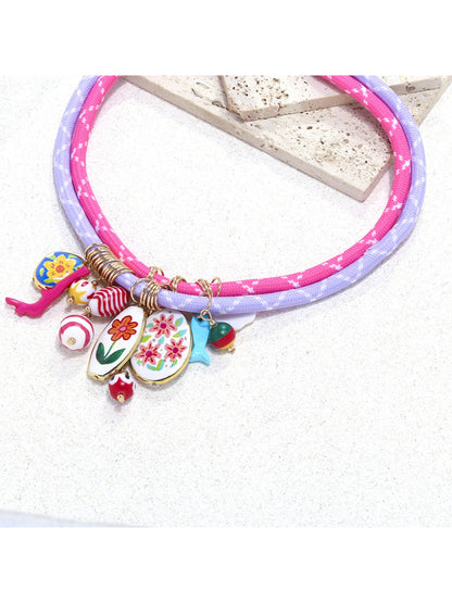 Side view of Neckit Charm Cluster Necklace with clustered charms on rope chain