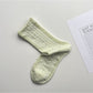 Pair of Rufia lace white mid-calf socks laid side by side highlighting lace design